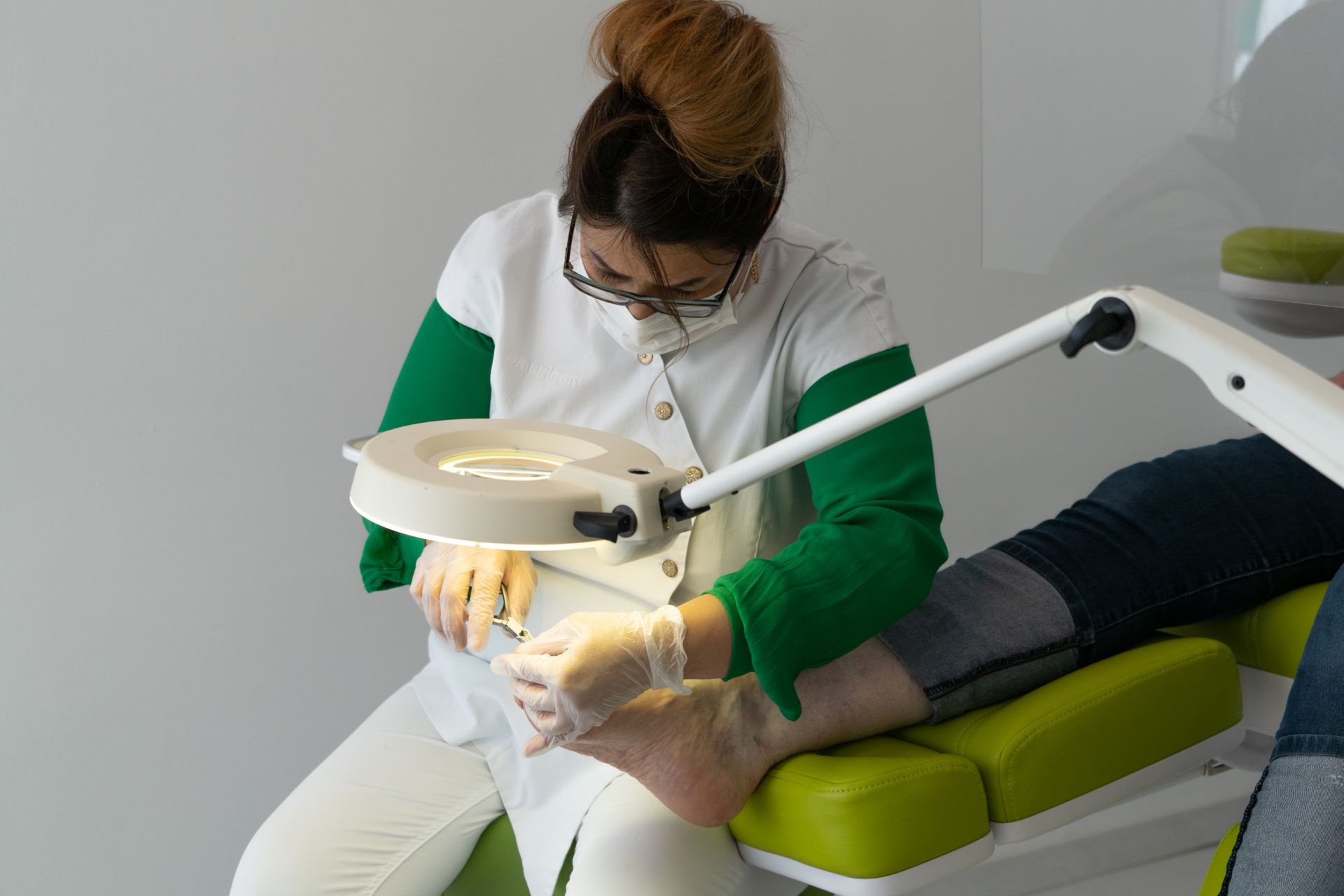 Medizinische Fußpflegerin behandelt konzentriert die Füße einer Patientin